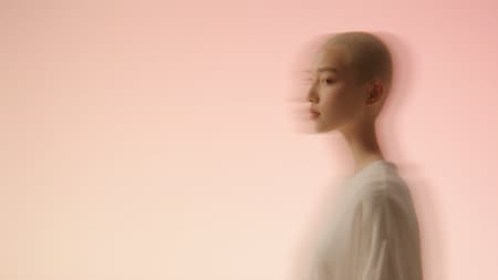 A single character on the right third in soft studio light. The background is a smooth blush to cream gradient. Keep styling clean and modern. Leave the entire left side open for the headline. No props, no text.