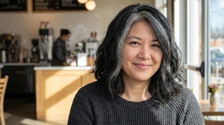 Smiling Woman With Grey Streaks In Cafe Adds a medium black hair with grey streaks.