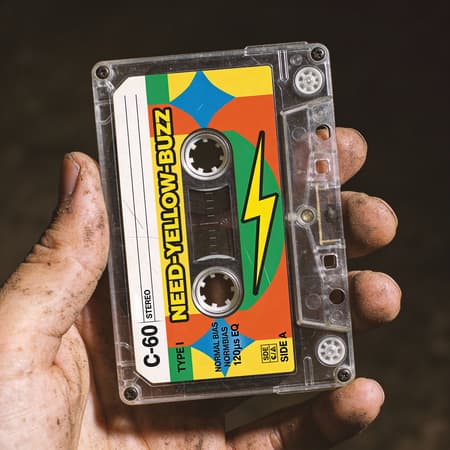 Photorealistic Close-up Of A Dirty Photorealistic close-up of a dirty hand holding a vintage transparent cassette tape against a dark, out-of-focus background. The cassette label has a vibrant, retro design with geometric shapes in yellow, orange, blue, and green. A prominent yellow lightning bolt is on the right side, and the text "NEED-YELLOW-BUZZ" is boldly displayed in yellow with a black outline. Other text includes "C-60," "STEREO," "TYPE I," "NORMAL BIAS," "120µs EQ," and "SIDE A." The lighting is soft but highlights the texture of the hand and the subtle scratches on the cassette. The mood is nostalgic and a bit gritty.