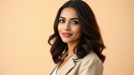 A confident Arab woman in her early 30s stands gracefully against a soft, sandy beige background, her expression serene and self-assured. The warm tones highlight her features, lending an air of elegance, as she gazes directly into the camera with a subtle, knowing smile. Her dark hair is styled in gentle waves, complementing her sophisticated attire that reflects a blend of contemporary and traditional elements. The overall composition exudes a sense of empowerment and timeless beauty.