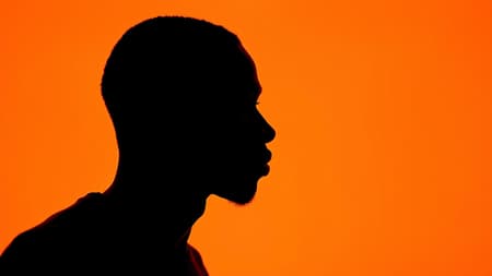 Photography portrait highlighting contrast features, side profile silhouette of a black man against a vivid orange background, captured using a camera setup with a large aperture to emphasize the silhouette's sharp outline. A low ISO setting preserves the color's depth and clarity, ensuring a smooth, grain-free image. The photorealistic shot is in ultra-high definition, aspect ratio 9:16, introducing a hint of artistic unpredictability with chaos infused at 1.7, stylized in a raw, unembellished manner. Photography portrait highlighting contrast features, side profile silhouette of a black man against a vivid orange background, captured using a camera setup with a large aperture to emphasize the silhouette's sharp outline. A low ISO setting preserves the color's depth and clarity, ensuring a smooth, grain-free image. The photorealistic shot is in ultra-high definition, aspect ratio 9:16, introducing a hint of artistic unpredictability with chaos infused at 1.7, stylized in a raw, unembellished manner.