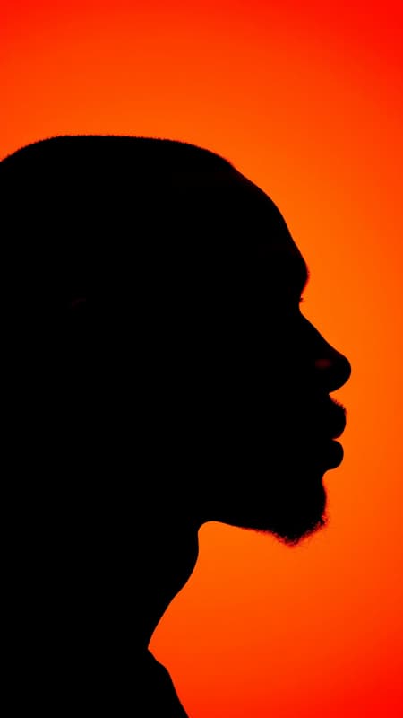 photography, portrait of contrast, side profile silhouette of a black man, vivid orange background, captured using a camera setup with a large aperture to emphasize the silhouette's sharp edge, low ISO maintaining deep color saturation and minimal noise, highly photorealistic, 4K UHD resolution, aspect ratio 9:16, subtle creative variations within a raw and natural style, touch of chaos at 1.7 photography, portrait of contrast, side profile silhouette of a black man, vivid orange background, captured using a camera setup with a large aperture to emphasize the silhouette's sharp edge, low ISO maintaining deep color saturation and minimal noise, highly photorealistic, 4K UHD resolution, aspect ratio 9:16, subtle creative variations within a raw and natural style, touch of chaos at 1.7